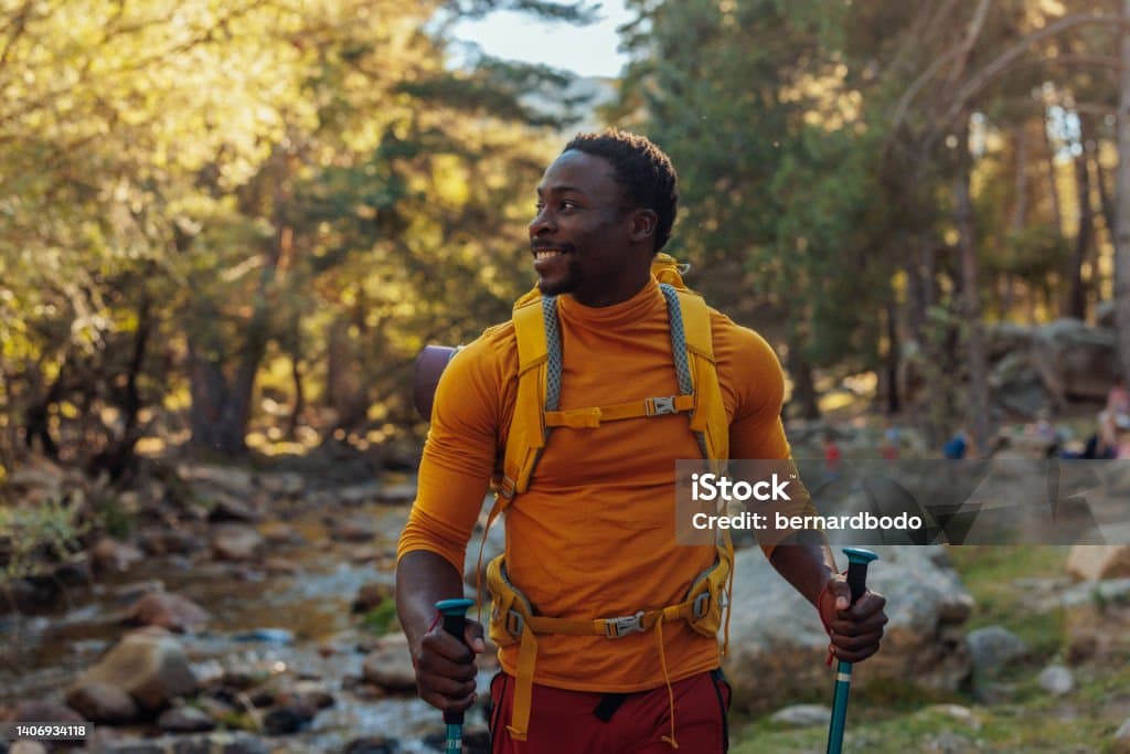 A man hiking with an orange shirt.